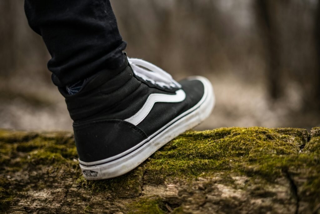  A pair of black and white Vans Sk8 Hi sneakers displayed against a neutral background, showcasing their iconic design.